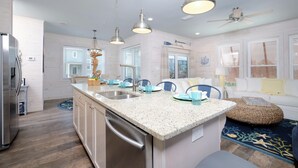 A modern kitchen with granite countertops, stainless steel appliances, and pendant lighting. - Beachside Cottage 2BR-3BA. Now booking for Summer! (Orange Beach)