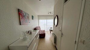 A compact bedroom with a bed, a dresser, a mirror, and a window with curtains. - Cozy apartment facing Thau pond, pet friendly (Balaruc-les-Bains)