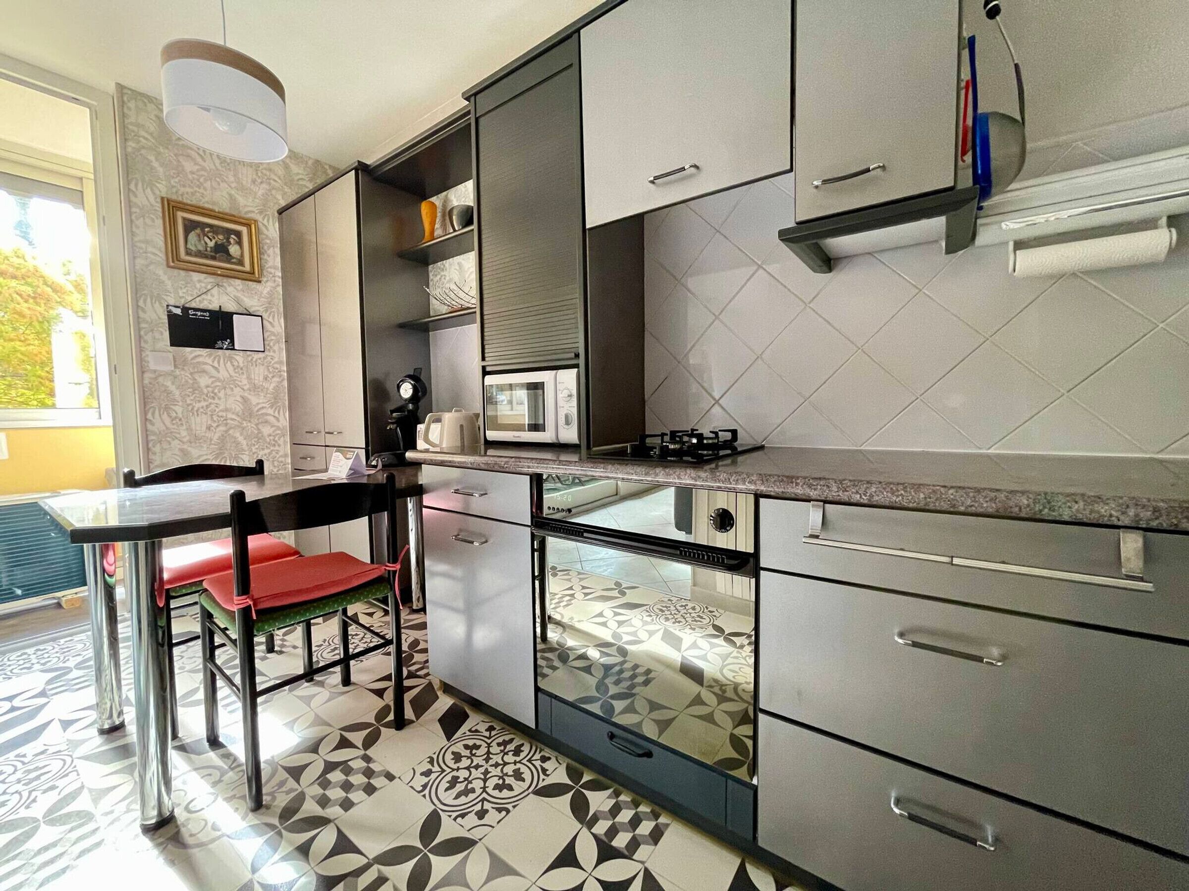 Una cucina moderna con forno a microonde integrato, piano cottura a gas e pensili in acciaio inossidabile.