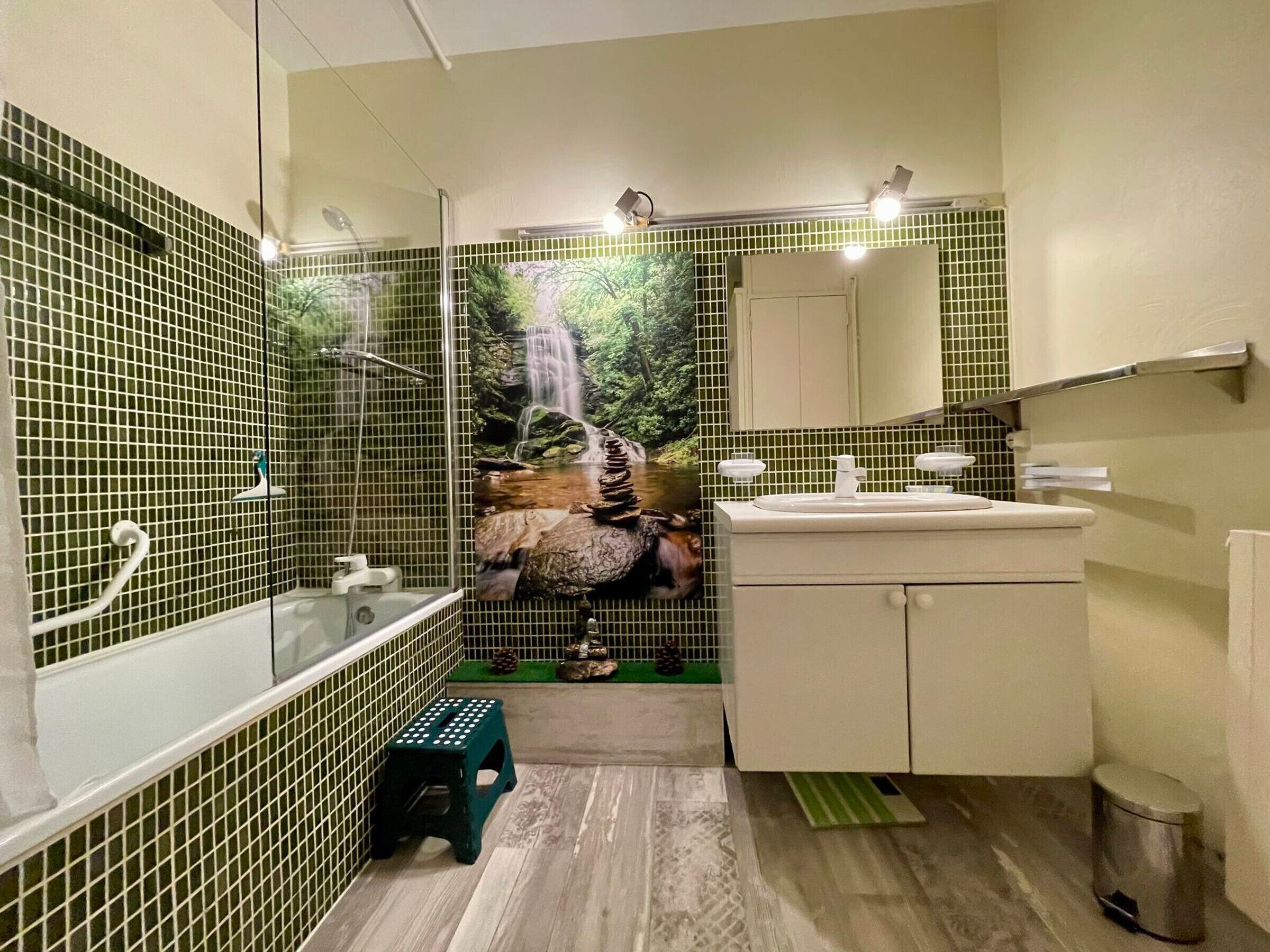 Un baño con ducha, lavabo y espejo.