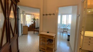 A spacious living area with a wooden coffee table, a bookshelf, and a dining area with a table and chairs.
