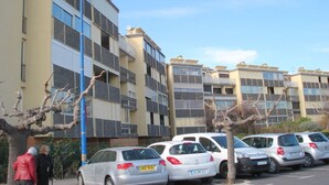A multi-story residential building with a parking lot.