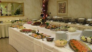 Una mesa de buffet con diferentes alimentos y un espejo en la pared.
