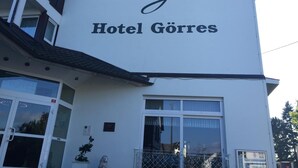 Un edificio con un cartel que dice "Hotel Görres" y un símbolo de corona encima del texto.