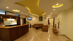 A hotel lobby with a reception desk, seating area, and decorative elements. - Hotel Sanobar (Udaipur)