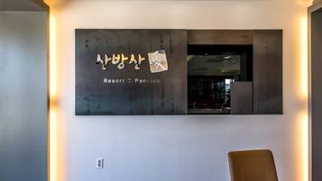 A modern interior with a wall-mounted sign reading "Resort & Pension" in Korean.