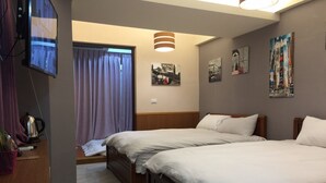 Quarto de hotel com duas camas, televisão, chaleira e janela com cortinas.