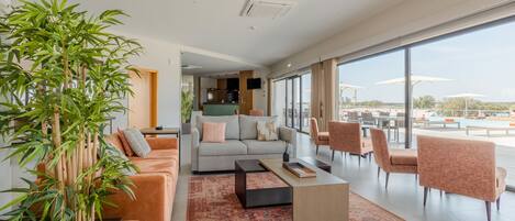 A modern hotel lobby with a sofa set, a coffee table, and a large plant.