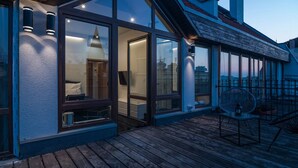 A modern building with large windows, a wooden deck, and outdoor seating. - RentPlanet - Apartamenty Ruska (Wroclaw)
