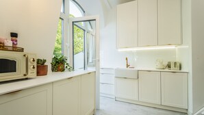 A modern kitchen with white cabinetry, a microwave, a kettle, and a toaster. - Baltic Apartments-Willa Carmen 14 (Swinoujscie)