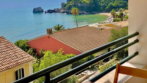 A balcony with a view of a coastal area, including a beach and rocky outcrops. - Corfu Island Apartment 91 (Corfu)