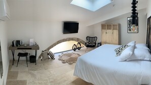 Une chambre à coucher comprenant un lit, un bureau, une chaise, une télévision et une armoire.
