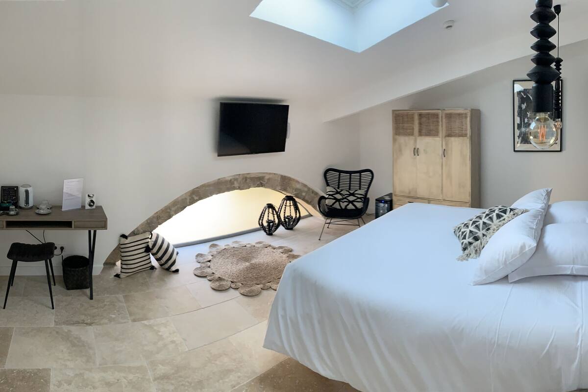 Un dormitorio con cama, escritorio, silla, televisor y armario.