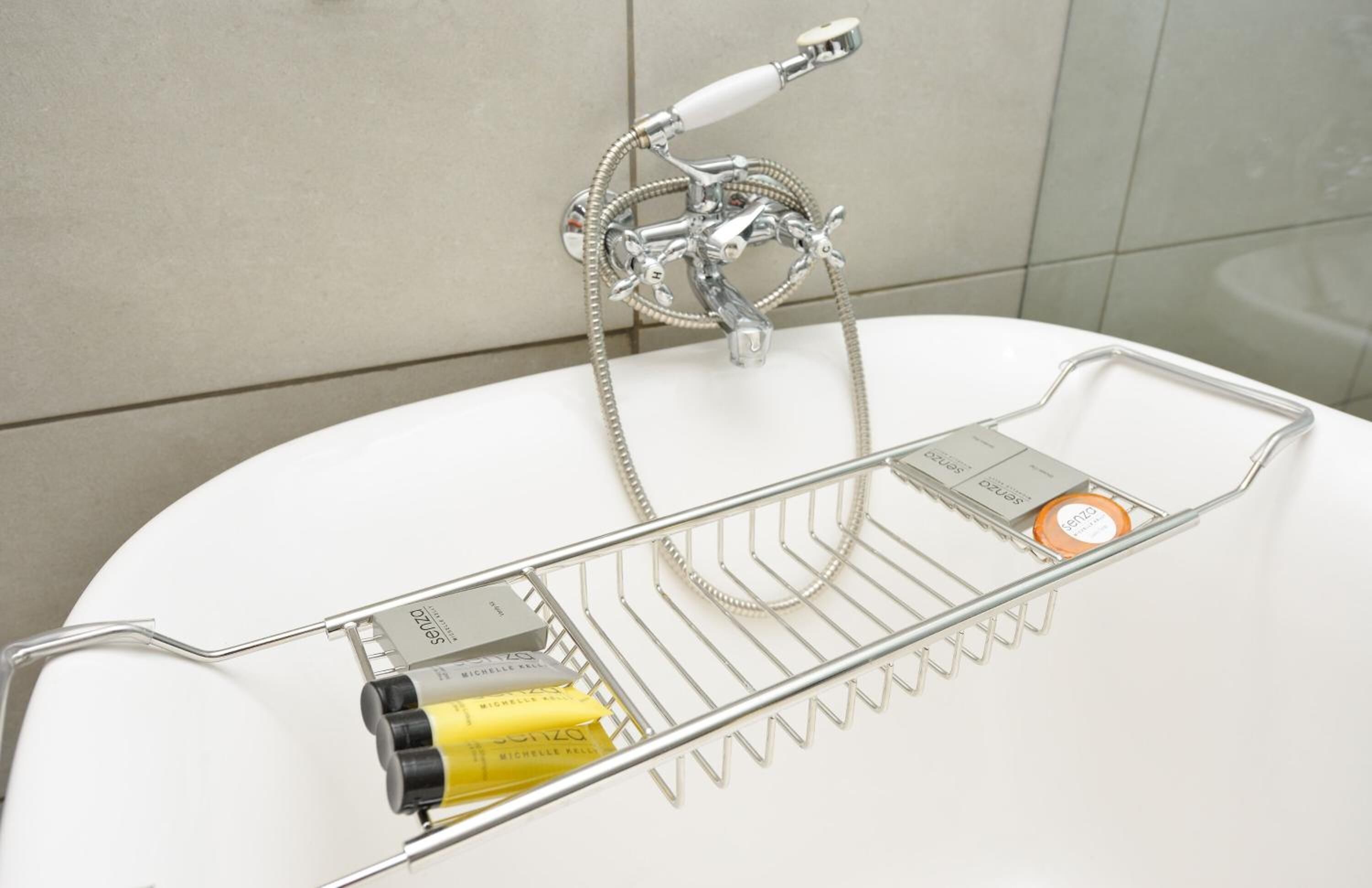 Un baño con lavamanos blanco, grifo de cromo y ducha.