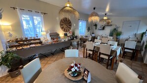 A dining area with a buffet, round tables, and hanging lights. - Hotel le Médieval (Aigues-Mortes)