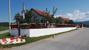 Ein Gebäude mit rotem Dach, weißen Wänden und einem roten Zaun mit Blumen.