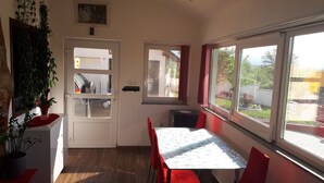 Eine kleine Küche mit Essbereich, einem Kühlschrank, einem Fenster mit Blick und einem Blumentopf.