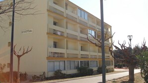 A multi-story building with balconies, a "No Entry" sign, and a sign reading "LE SAGITTAIRE".