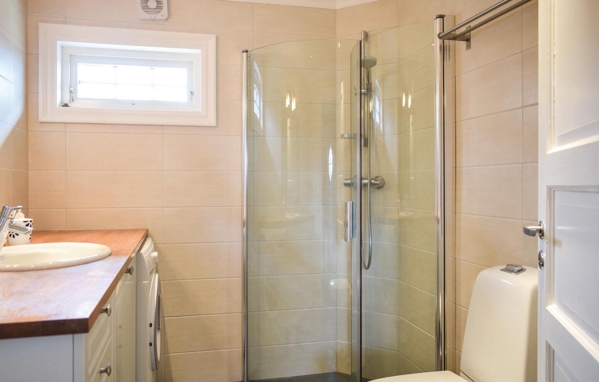 Ein modernes Badezimmer mit Duschkabine, Waschbecken und Toilette.