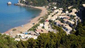 A coastal residential area with houses along the beach and a small pool area.