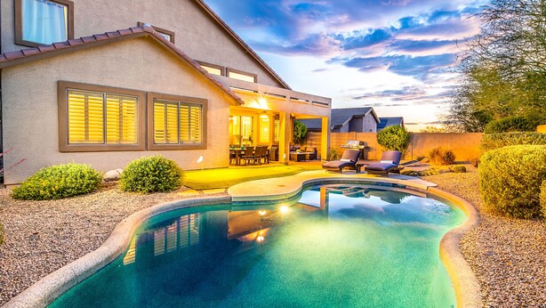 A modern house with a swimming pool, outdoor seating, and a patio area. - Prime Location, Heated Pool, Fun Game Room, Putting Green, Outdoor BBQ, & More (Phoenix)