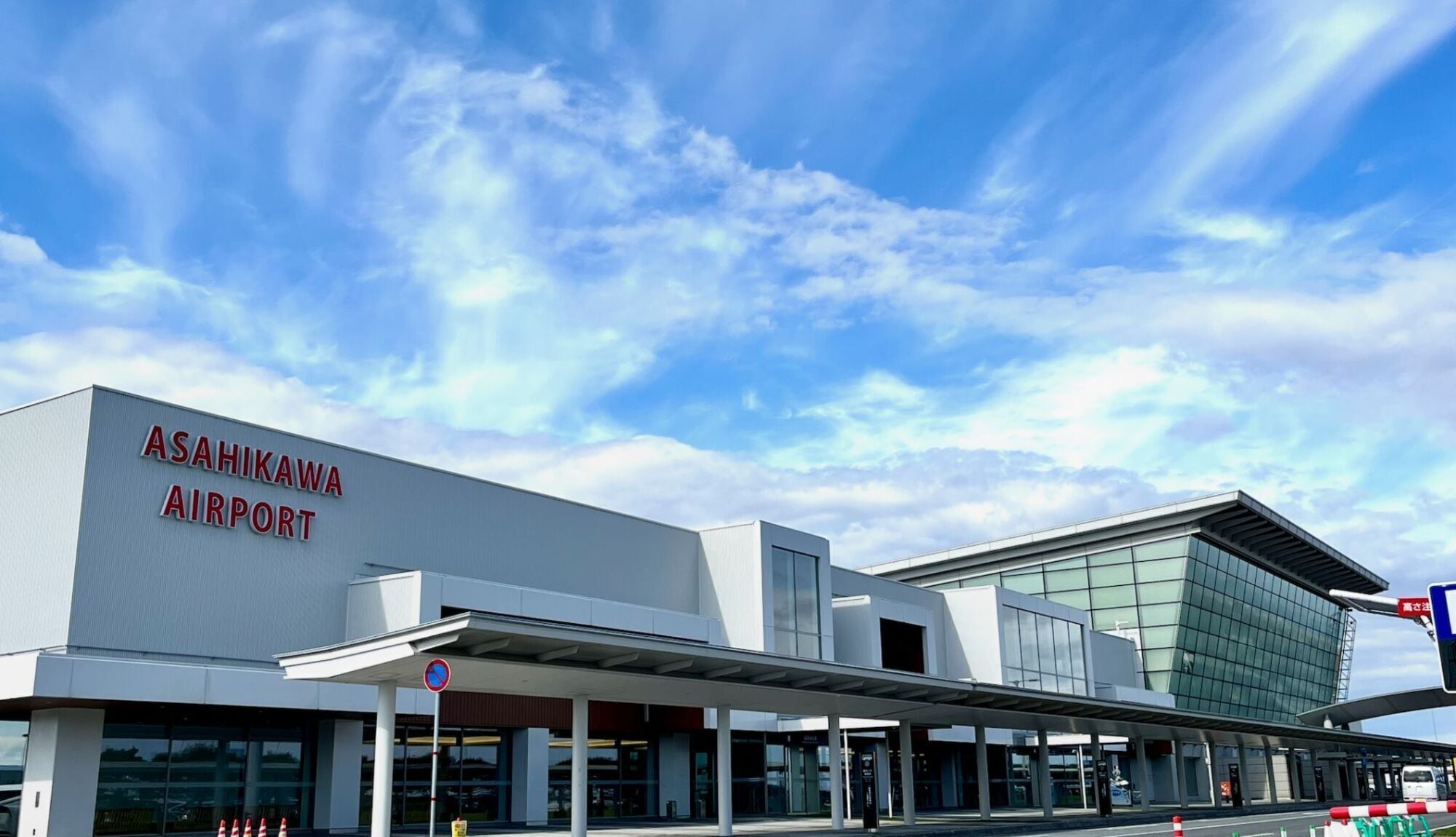 Asahikawa Airport with a modern building and clear skies.