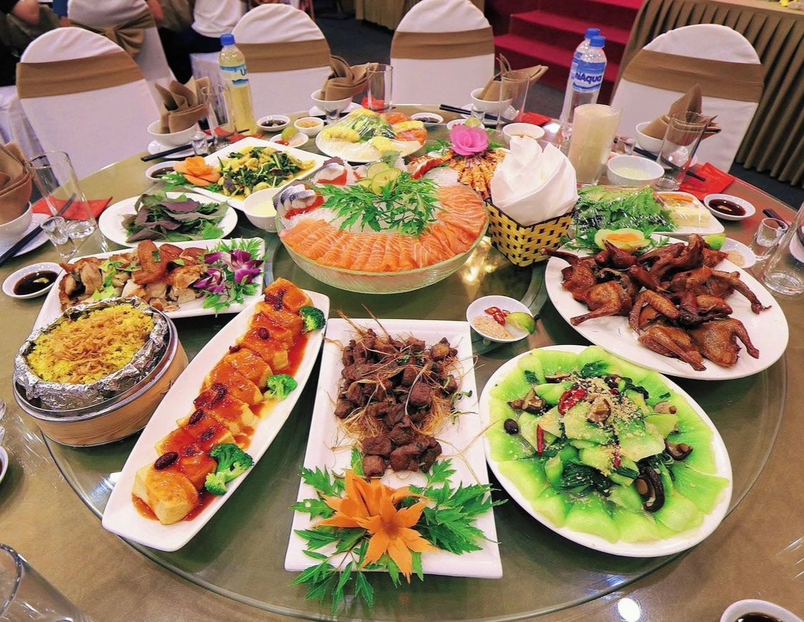 A table with various dishes, including seafood, vegetables, and meats, arranged for a meal.