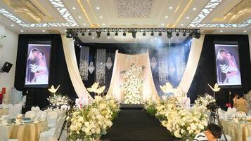 A stage with a floral arrangement, a podium, and two screens displaying images.