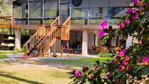 A modern building with a glass facade, wooden stairs, and outdoor seating. - Escape to Serenity at Suwannee River Rest – Pet-Friendly Lodge in North Florida (Branford)
