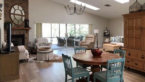 A spacious living area with a fireplace, a dining table, and a large wooden cabinet. - Escape to Serenity at Suwannee River Rest – Pet-Friendly Lodge in North Florida (Branford)