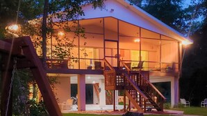 A two-story house with a balcony, a staircase, and a well-lit interior. - Escape to Serenity at Suwannee River Rest – Pet-Friendly Lodge in North Florida (Branford)