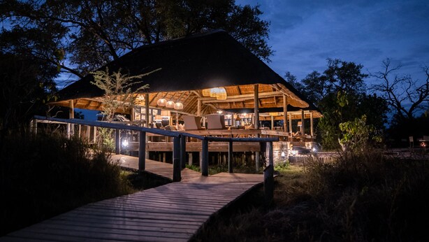 Una estructura de madera con una terraza cubierta y un sendero que la conduce.
