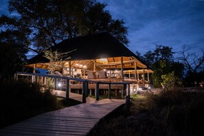 A wooden structure with a covered deck and a pathway leading to it.