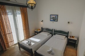 A hotel room with two beds, a painting, a lamp, and a window with curtains.