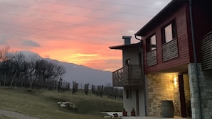 A two-story house with a stone foundation and a red exterior. - Agritur Verderame (Trento)