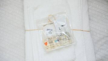 Une serviette blanche sur laquelle repose un petit sac en plastique contenant des articles pour bébé.
