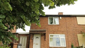 A two-story brick house with a front door, a window, and a visible number '158' on the door. - Cowsley House (Derby)