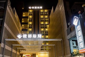 Entrada de un hotel con señalización iluminada y un diseño arquitectónico moderno.