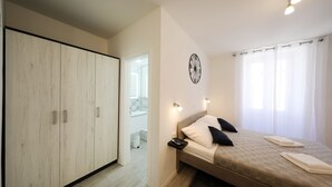 Un dormitorio con cama, mesita de noche y armario.