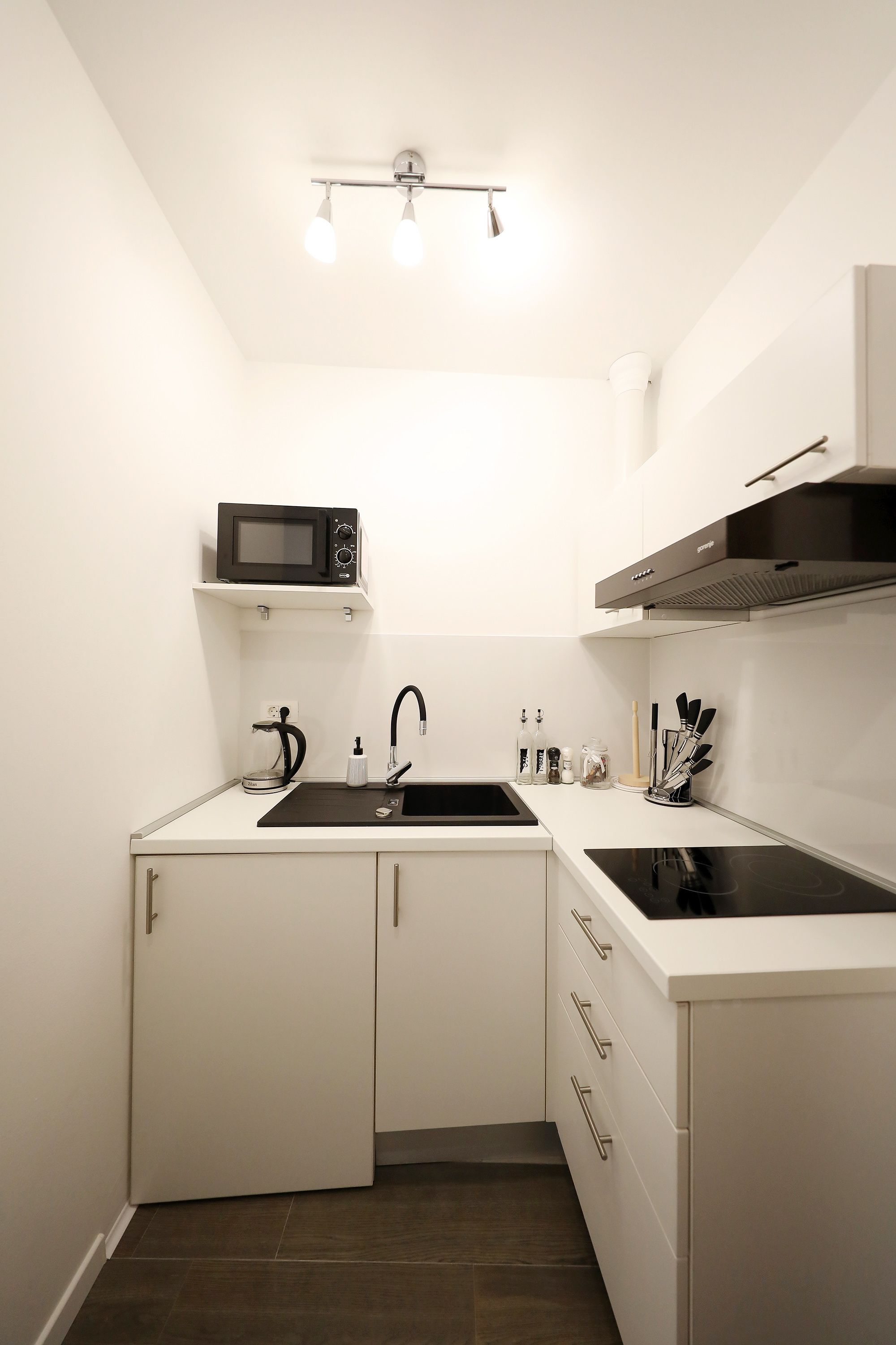 A compact kitchen with a microwave, sink, and stove.