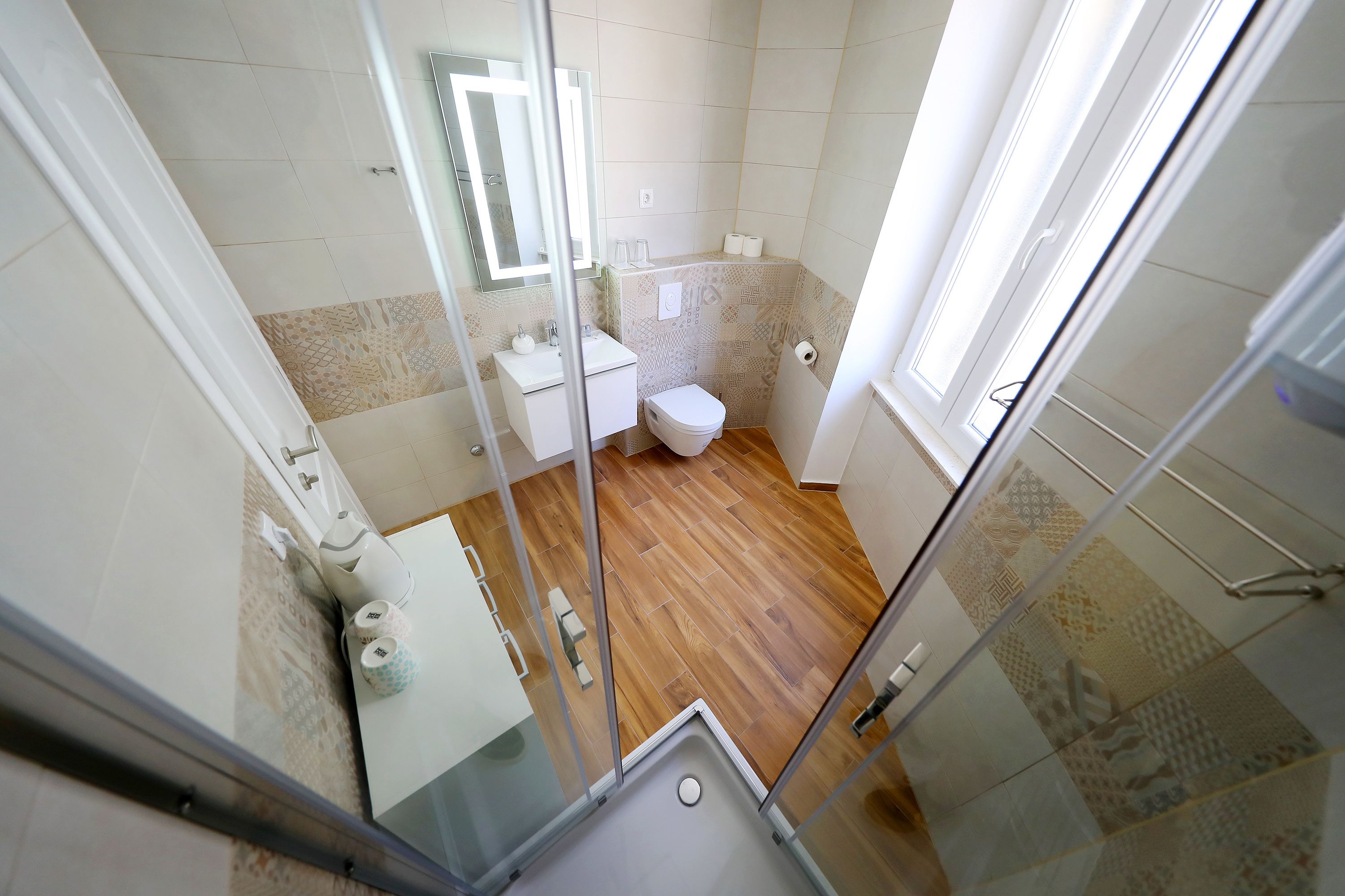 Un baño con inodoro, lavamanos y zona de ducha.