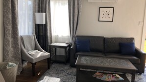 Een woonkamer met een bank, fauteuil, salontafel en een bijzettafeltje.