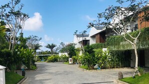A paved pathway leading to a building with a white facade and a sloped roof. - Villa Ommy Hideway Residence No.108 (Ungasan)