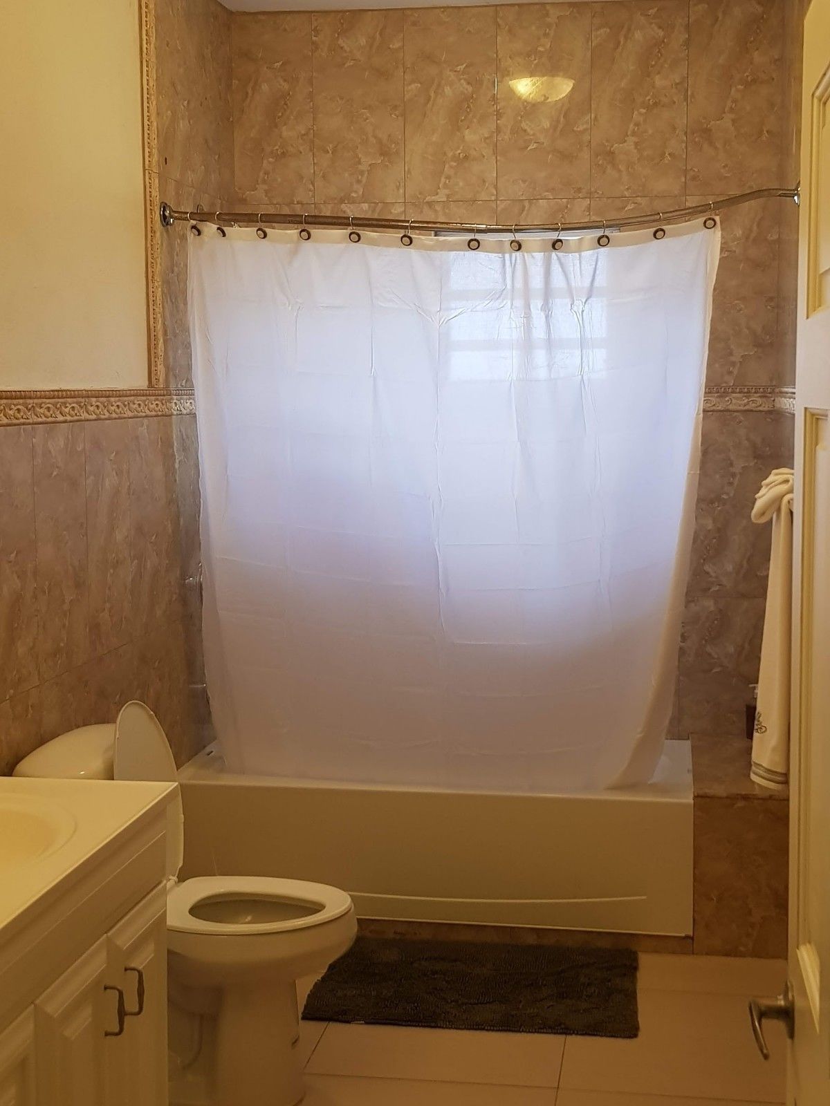 A bathroom with a bathtub, toilet, and vanity.