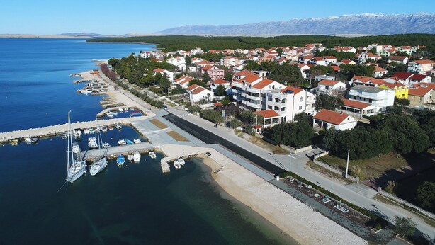 An aerial view of a coastal town with a marina, residential buildings, and a mountainous backdrop. - Apartment Maja (Vrsi)