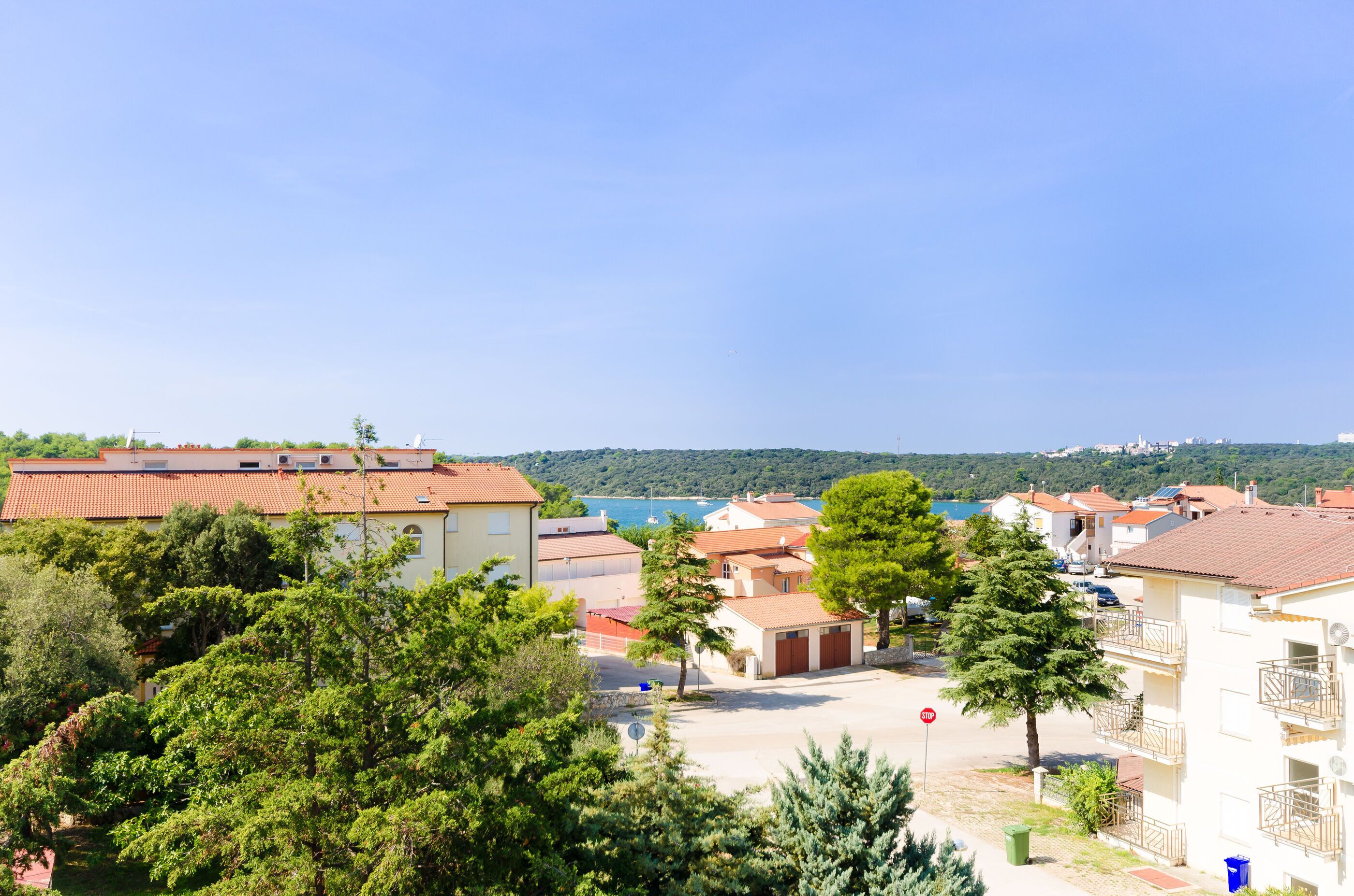 A residential area with houses, trees, and a clear blue sky.