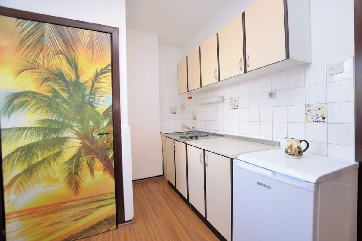 A kitchen with white cabinets, a sink, and a coffee maker.