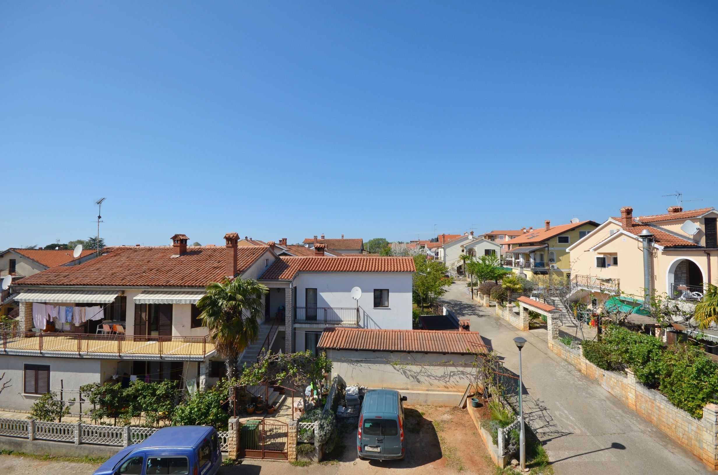 A residential area with houses, a street, and a parked car.