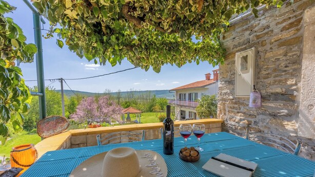 A table set outdoors with a bottle, glasses, and a basket of cookies. - House Dorino (Lanisce Krsan)