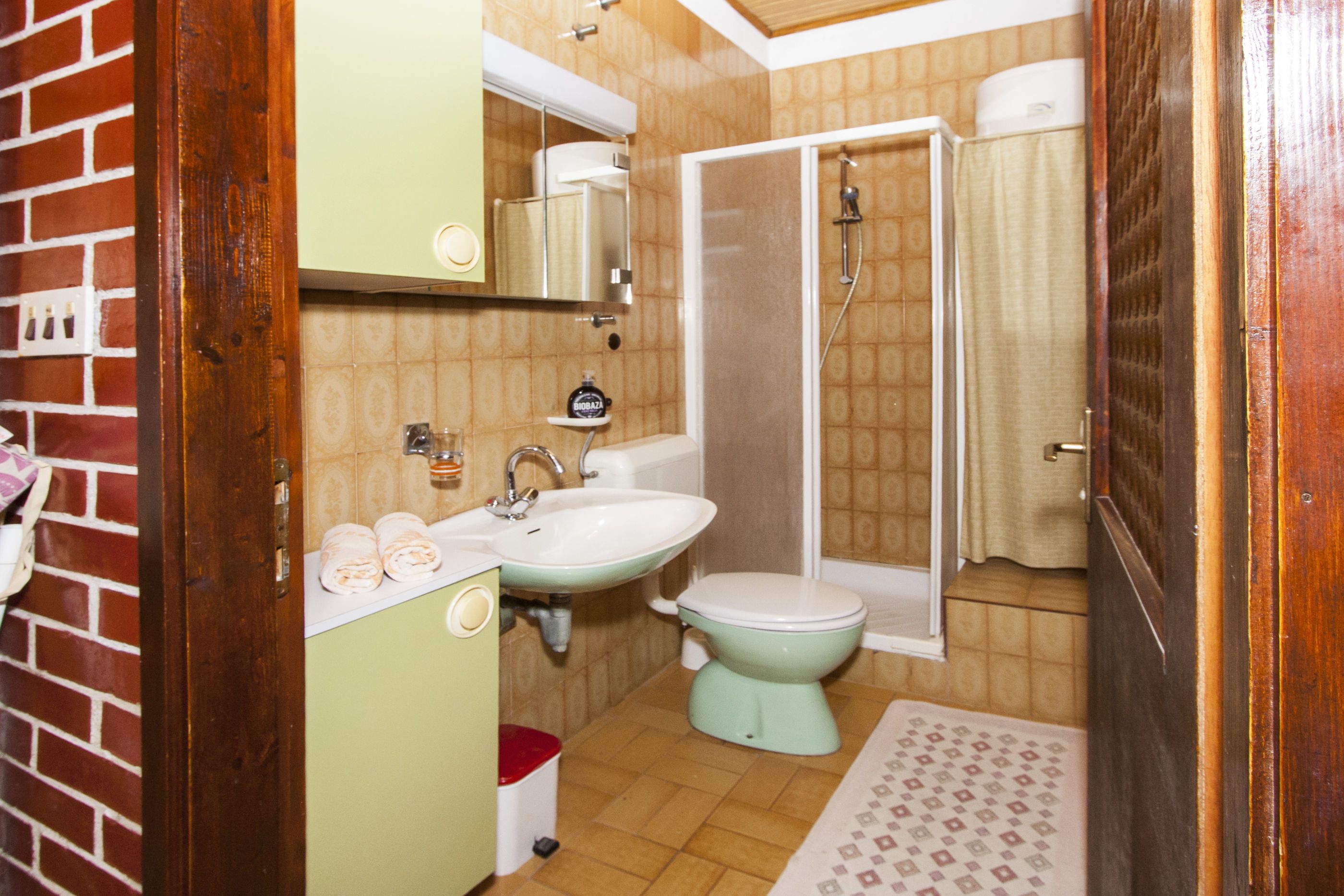 Une salle de bain avec un lavabo, des toilettes et une douche.